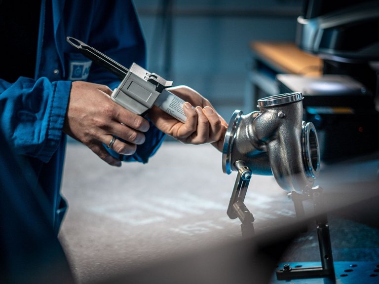 [Translate to Englisch:] an employee injects a silicone compound into a turbocharger
