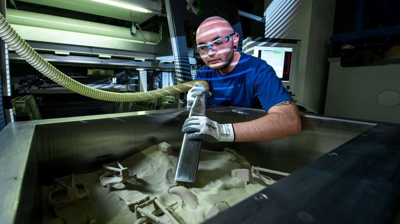 [Translate to Englisch:] Removal of printed molded parts from 3D phenolic printer